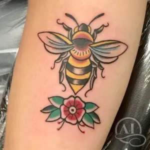 a tattoo of a bee and rose in a traditional style by BB at Artistic Impressions Tattoo Studio in Katy, Texas