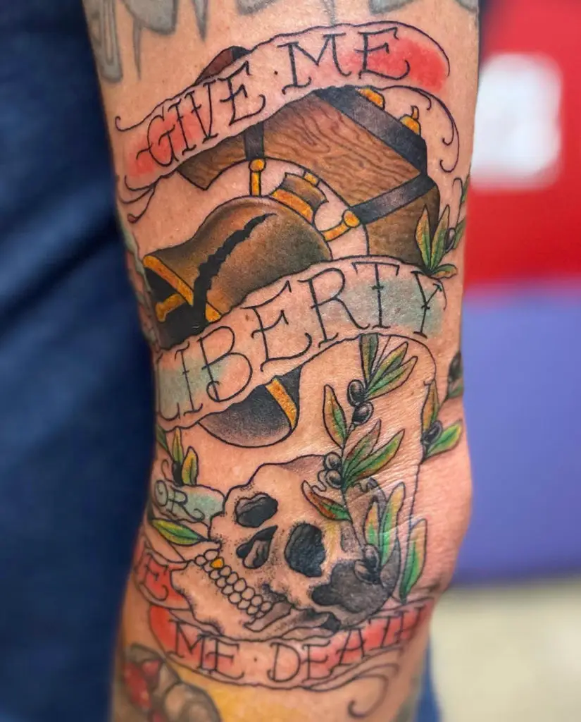 a tattoo of a liberty bell in a neo-traditional style and skull by Christina at Artistic Impressions Tattoo Studio in Cypress, Texas