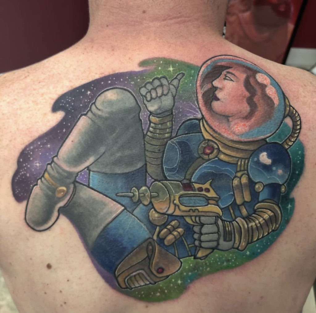 a tattoo of a female astronaut on the back by Mark Anthony at Artistic Impressions Tattoo Studio in Katy, Texas