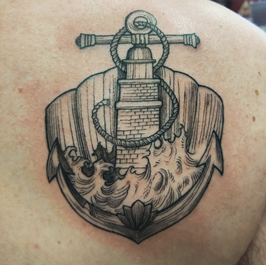 a tattoo of an anchor and lighthouse by Mark Anthony at Artistic Impressions Tattoo Studio in Katy, Texas