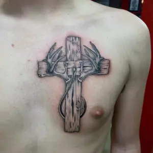 a tattoo of a Wooden cross with a fishing hook and Antlers by Peewee at Artistic Impressions Tattoo Studio in Cypress, Texas