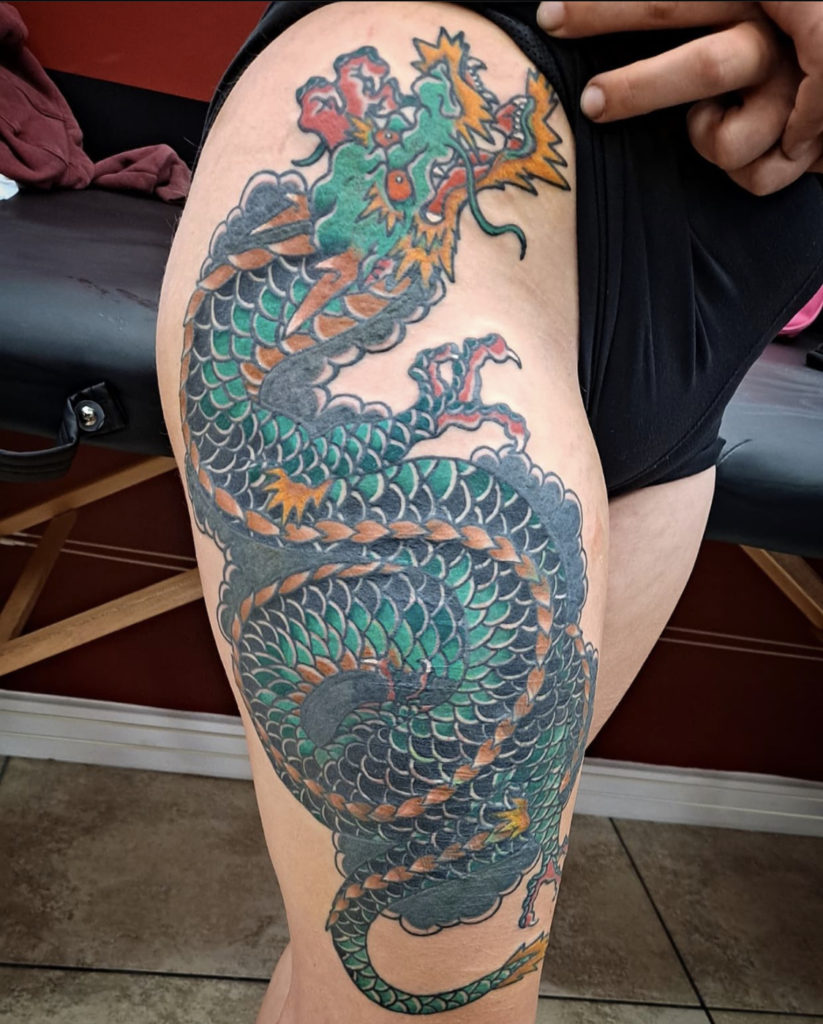 a traditional tattoo of a Japanese dragon on the outer leg by Mike Valadez at Artistic Impressions Tattoo Studio in Katy, Texas