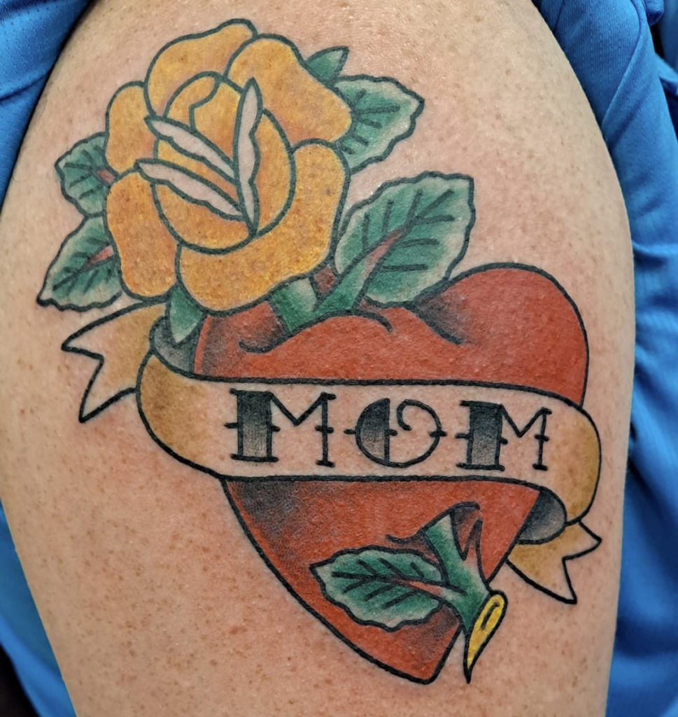 a traditional tattoo of a heart with a banner by Mike Valadez at Artistic Impressions Tattoo Studio in Katy, Texas