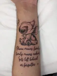 a tattoo of Walt Disney's Stitch with lettering